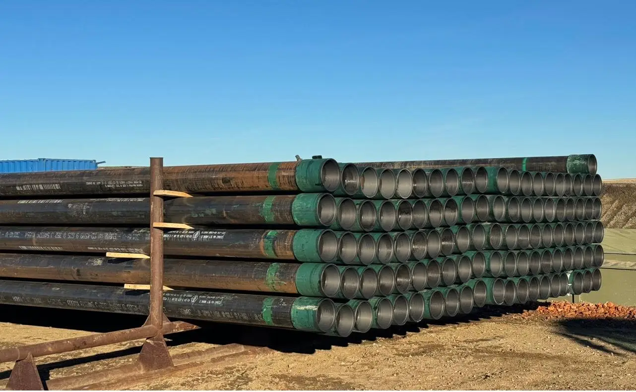 Stack of casing pipe with green couplings staged at a Bakken well site