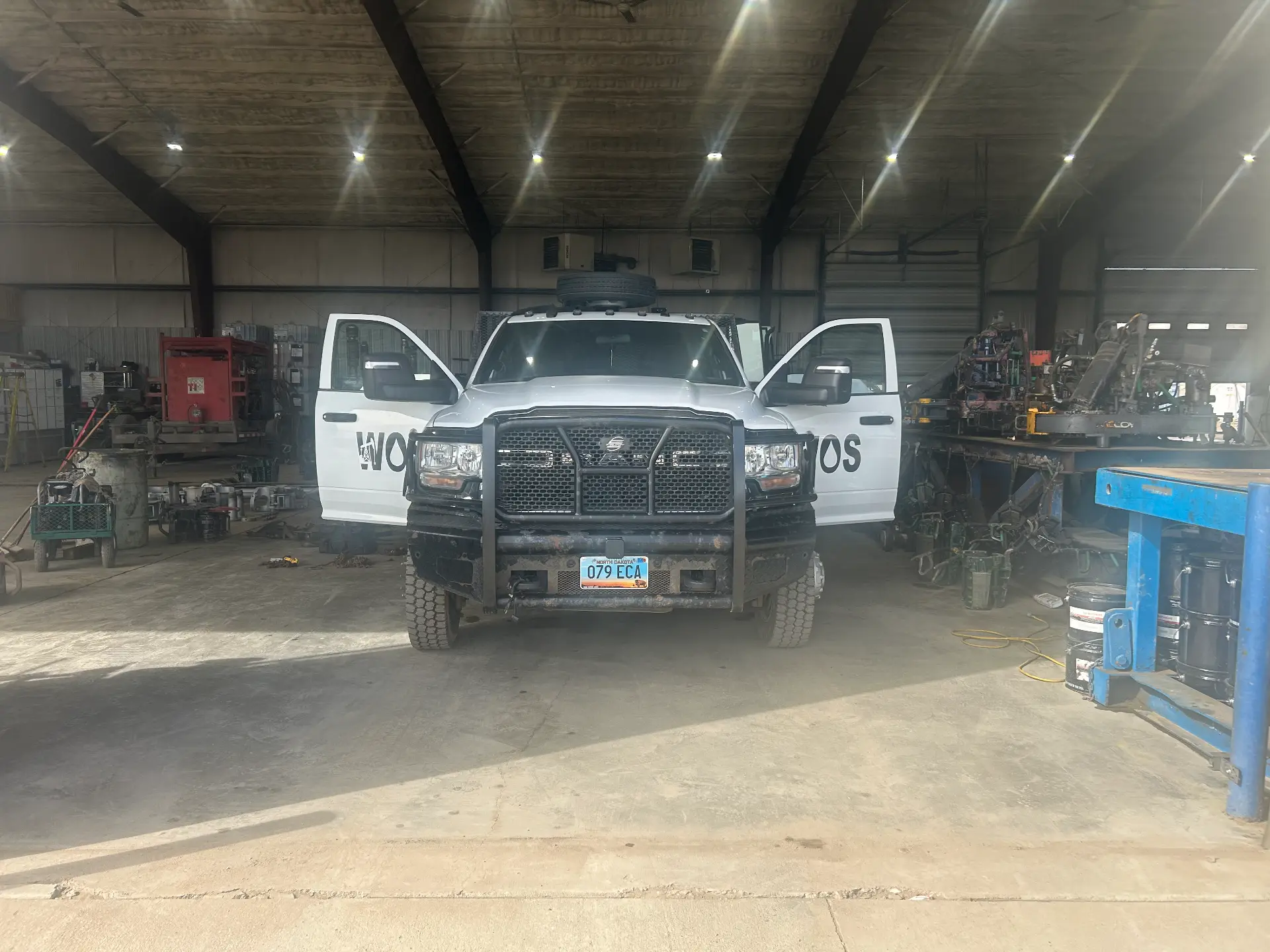 White Well Oiled Solutions service truck parked inside the shop next to the bucking unit