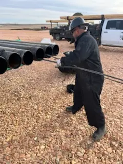 Crew member drifting casing in the field