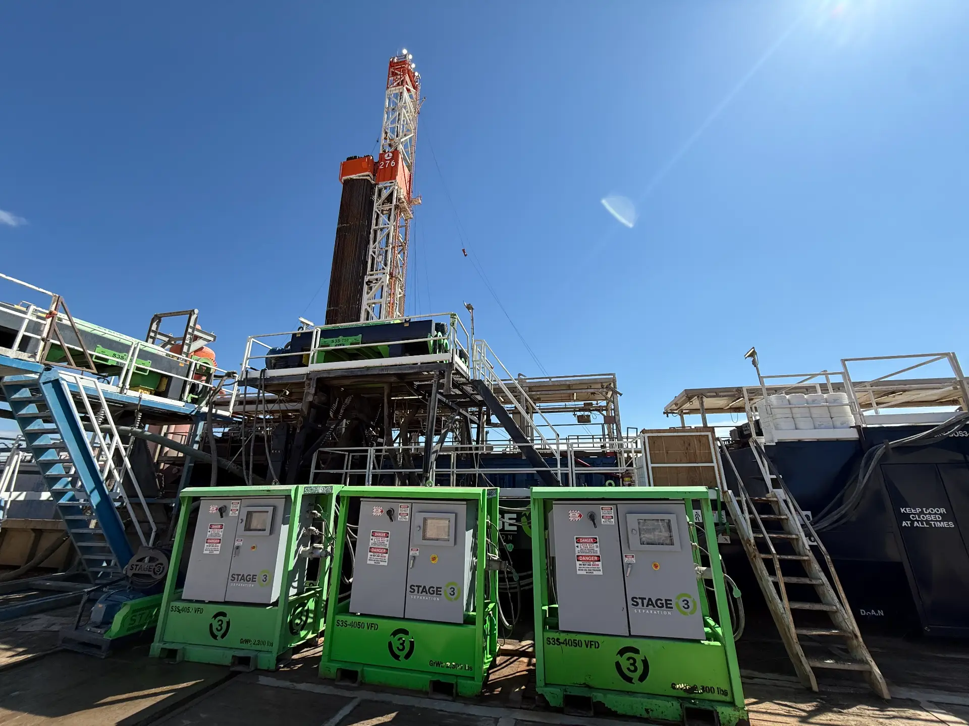 Drilling rig with Stage 1, 2, and 3 solids control units staged on the wellsite