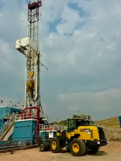 Drilling rig derrick with a WOS wheel loader supporting rig operations