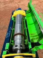 Close-up of a green and yellow solids control centrifuge bowl