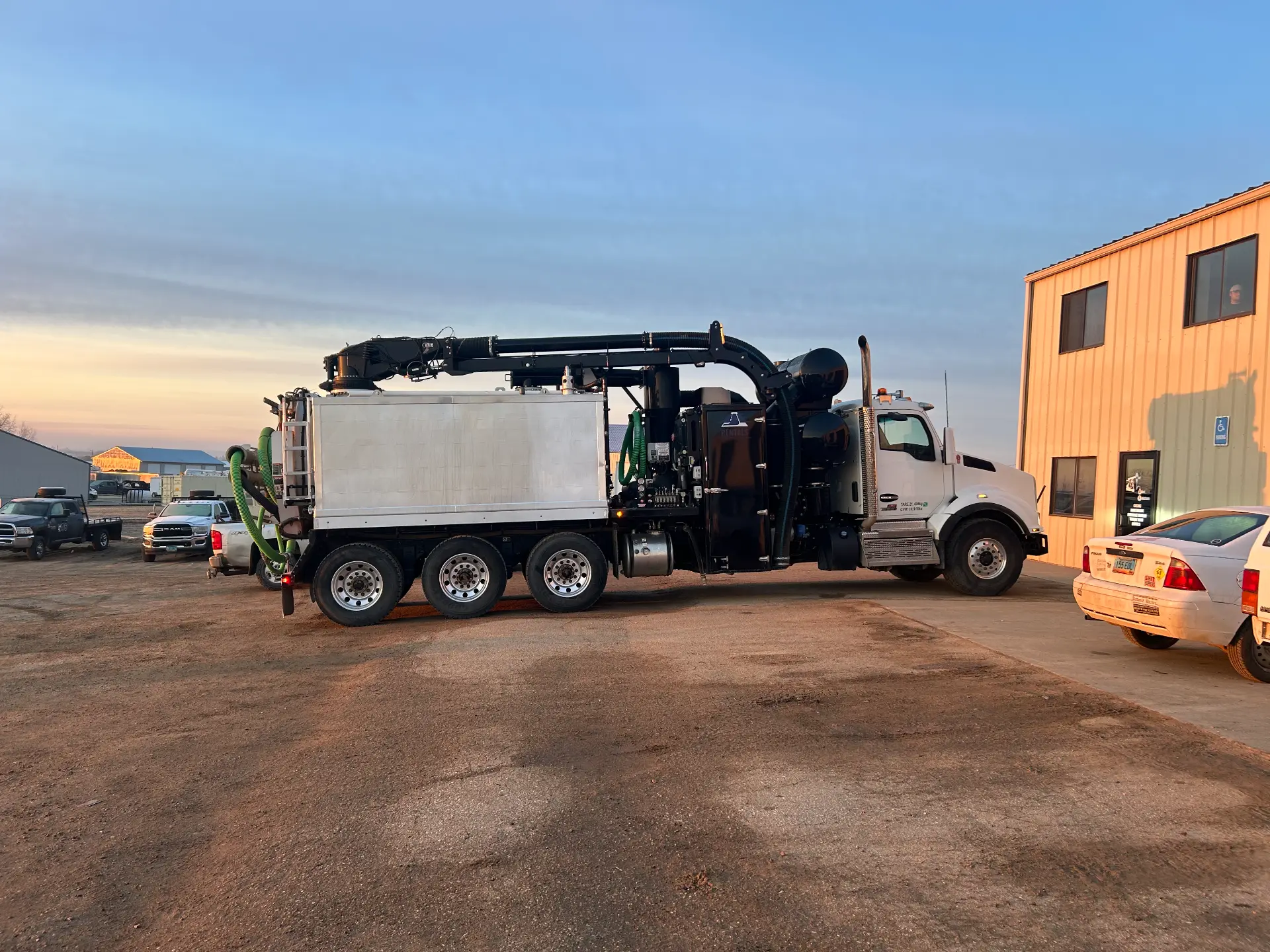 WOS Kenworth tri-axle hydrovac truck staged at the WOS yard at dusk