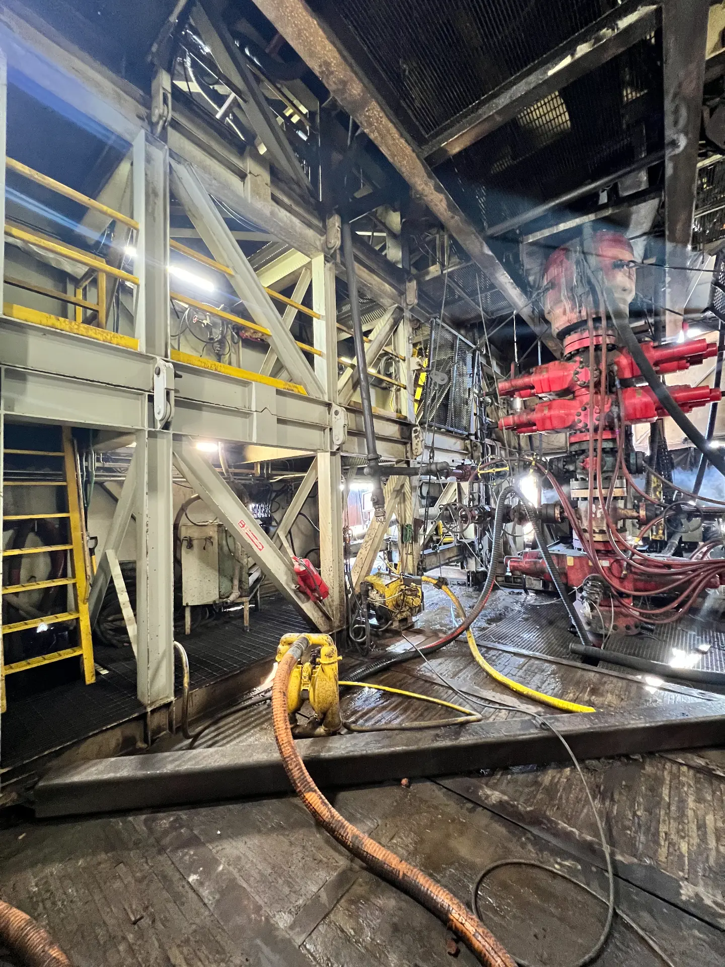 Pressure-washing crew cleaning rig substructure and frac wellhead iron with hot-water hoses