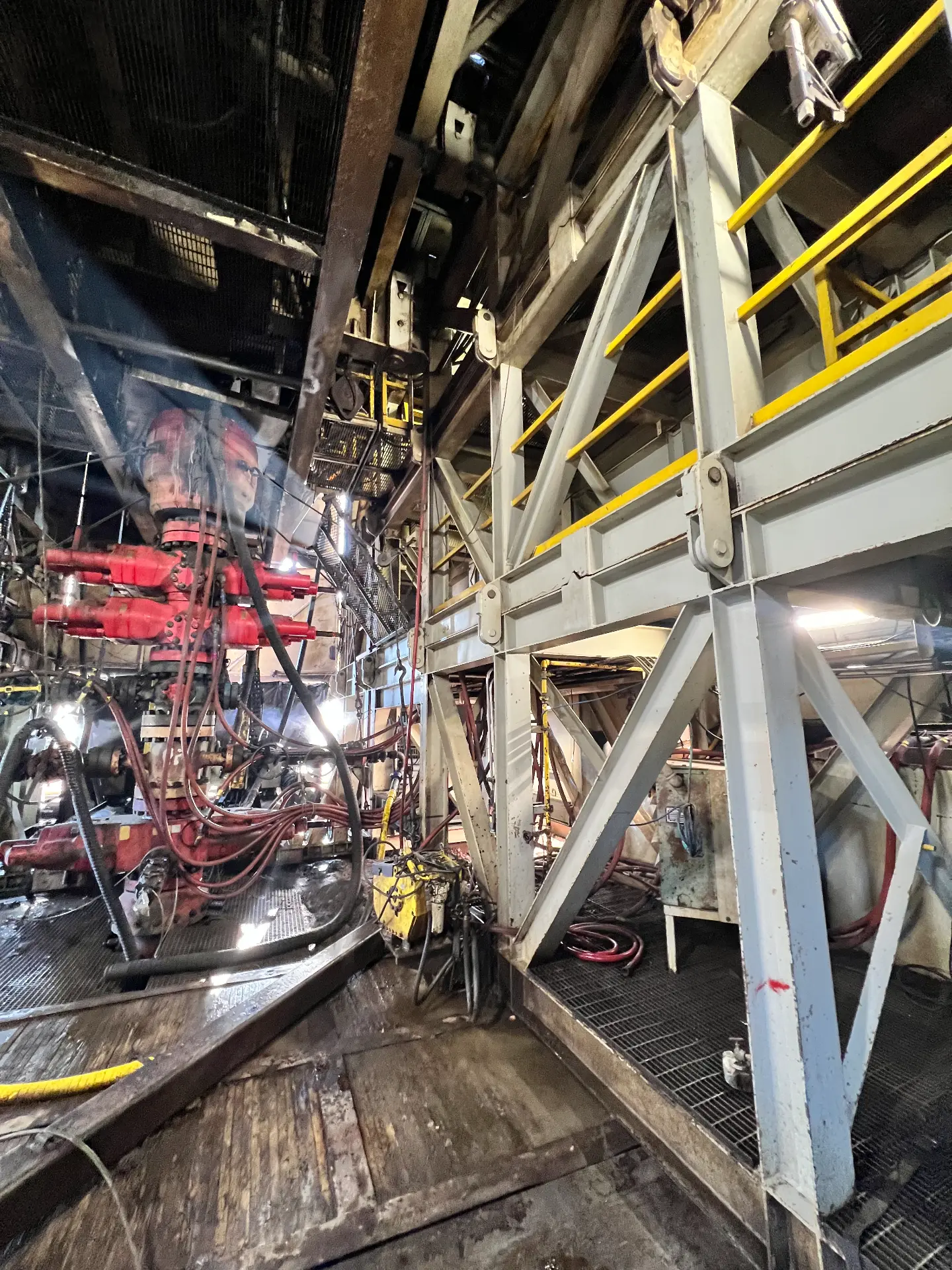 Steel substructure and BOP iron being pressure washed inside a workover rig