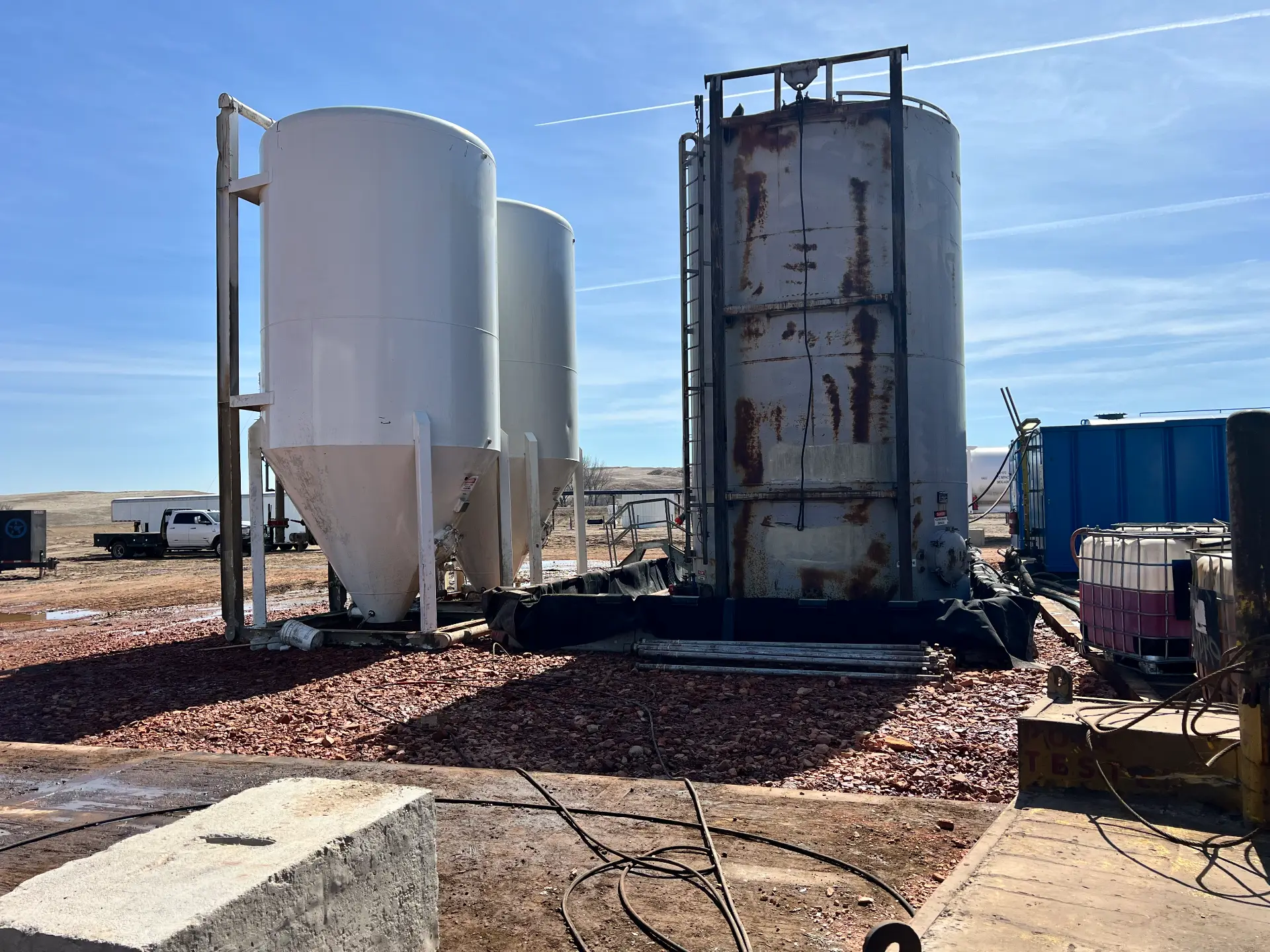 Tank battery and silos staged for pressure washing at a Bakken facility