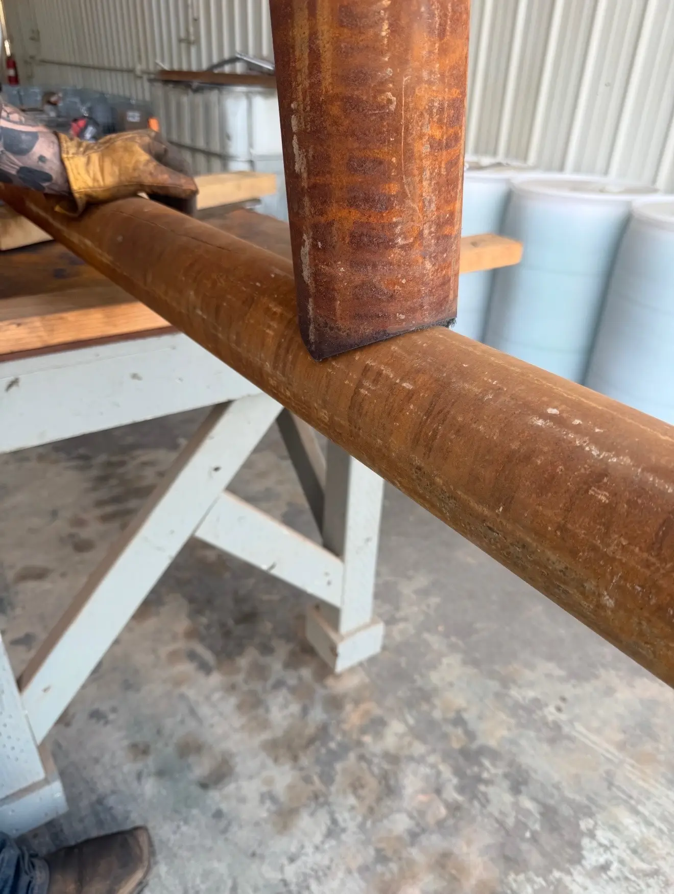 Close-up of a rental pipe rack stand supporting drill pipe in the shop