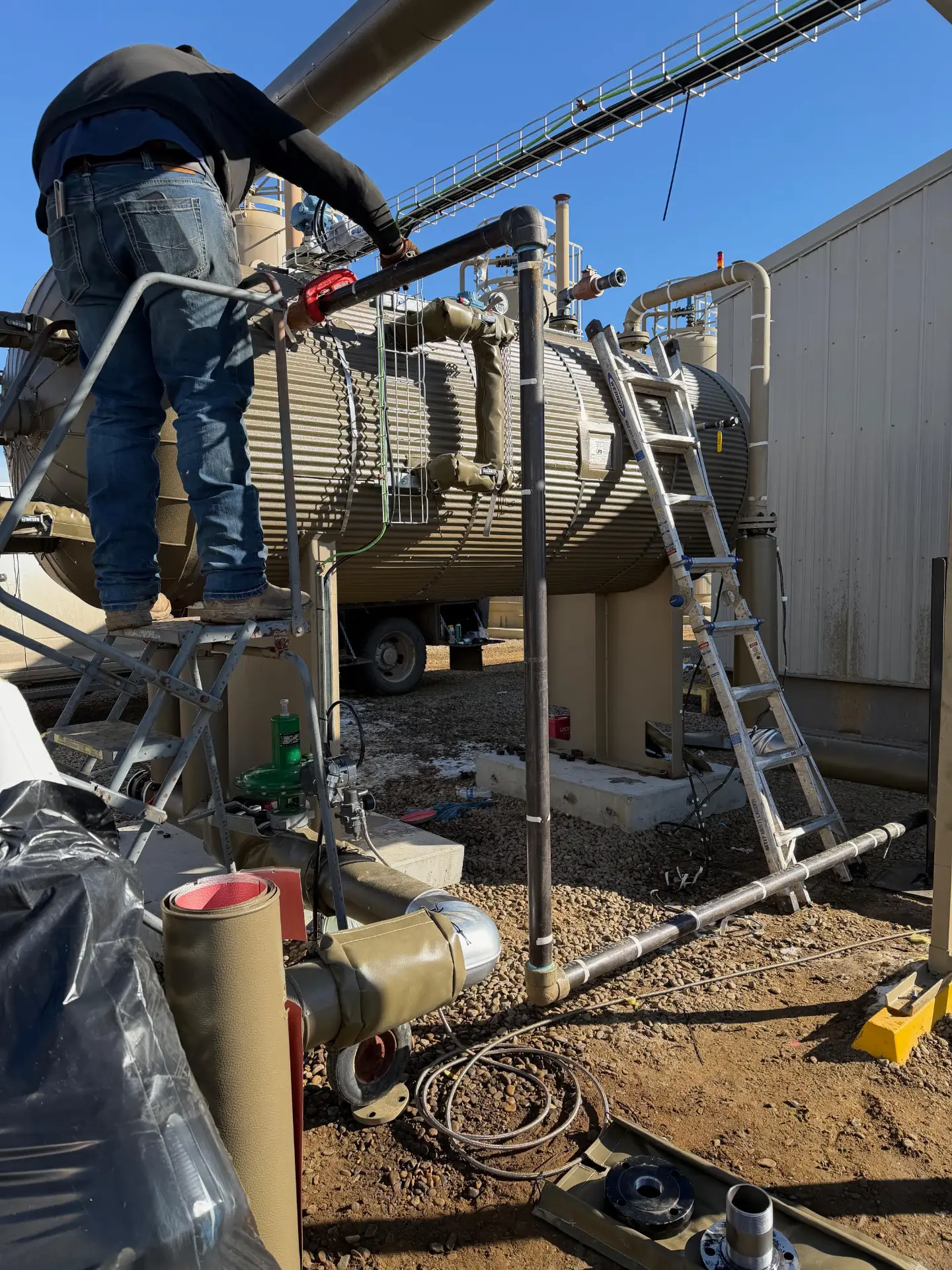 WOS technician on a platform servicing a separator vessel at a Bakken facility